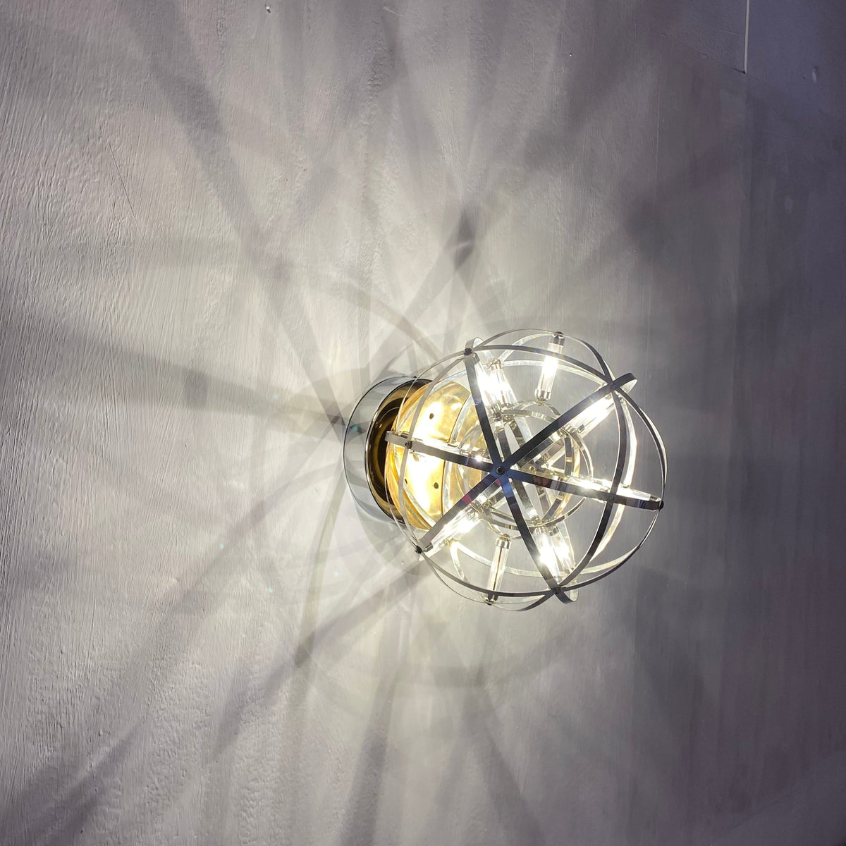 Atom sphere wall sconce lit, top view with shadow pattern