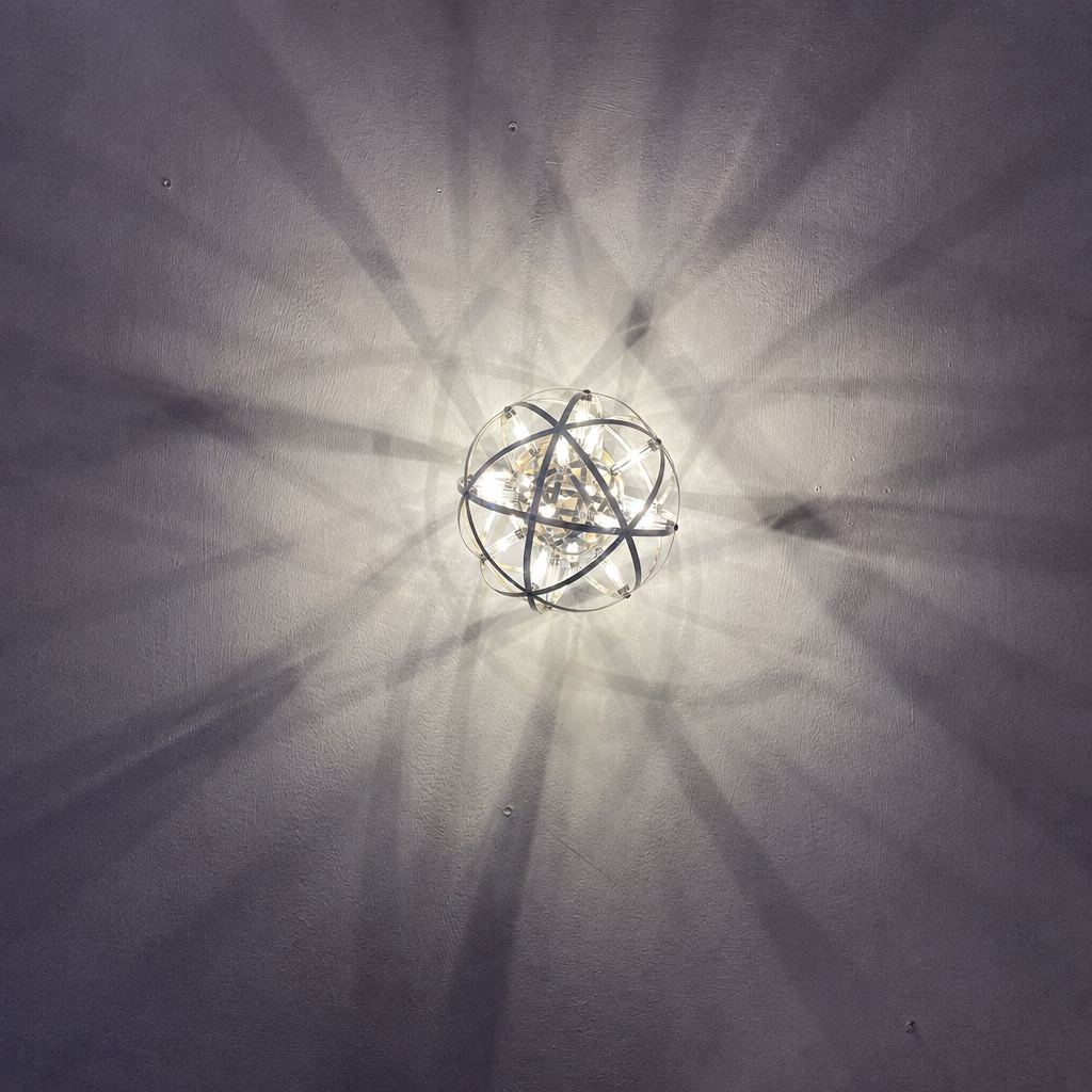 Atom sphere wall sconce lit, cropped square, side angle with shadow pattern